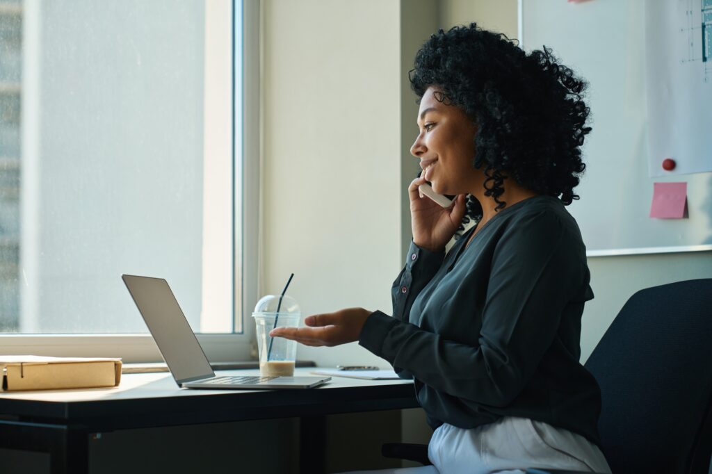 African american business woman communicates with clients on the phone